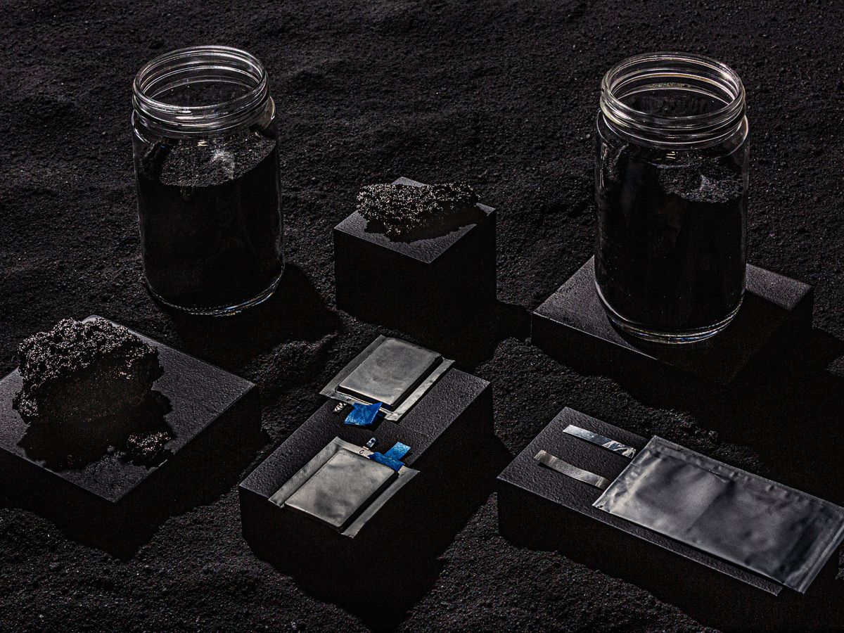 jars with black sand, porous rocks, and black container boxess sitting on black sand