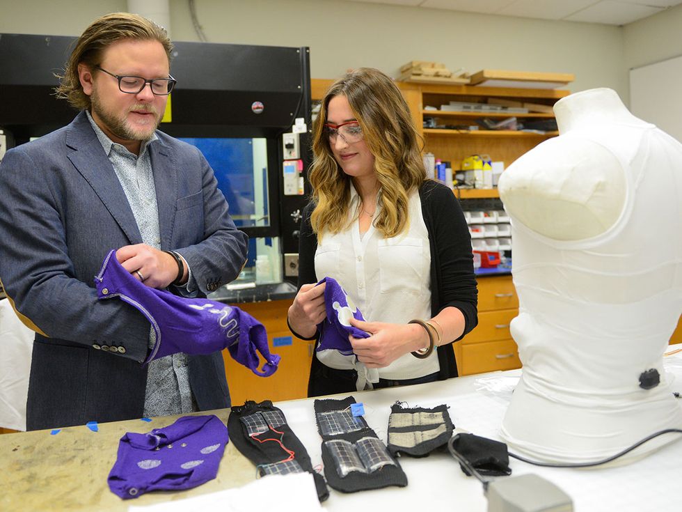 Jesse Jur (left) and designer Allison Bowles discuss a garment being designed for infants that will monitor their biometrics. The outfit is being fabricated by Jur's NEXT research group at North Carolina State University\u2019s Wilson College of Textiles.  