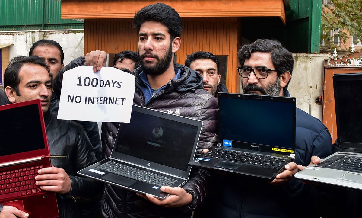 Kashmiri journalists hold laptops and a placard during a protest against the continuous ban on internet following the abrogation of Article 370 by the government of India on August 05.  Shot November 12, 2019