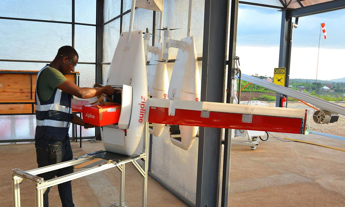Late 2018 IEEE Spectrum photo of a Zipline technician stowing a package of blood in the Zipline drone’s cargo bay.