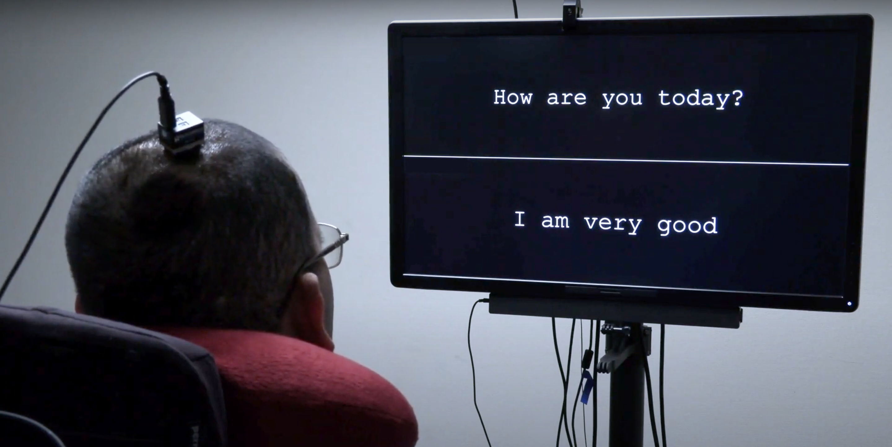 A man using an interface, looking at a screen with words on it.