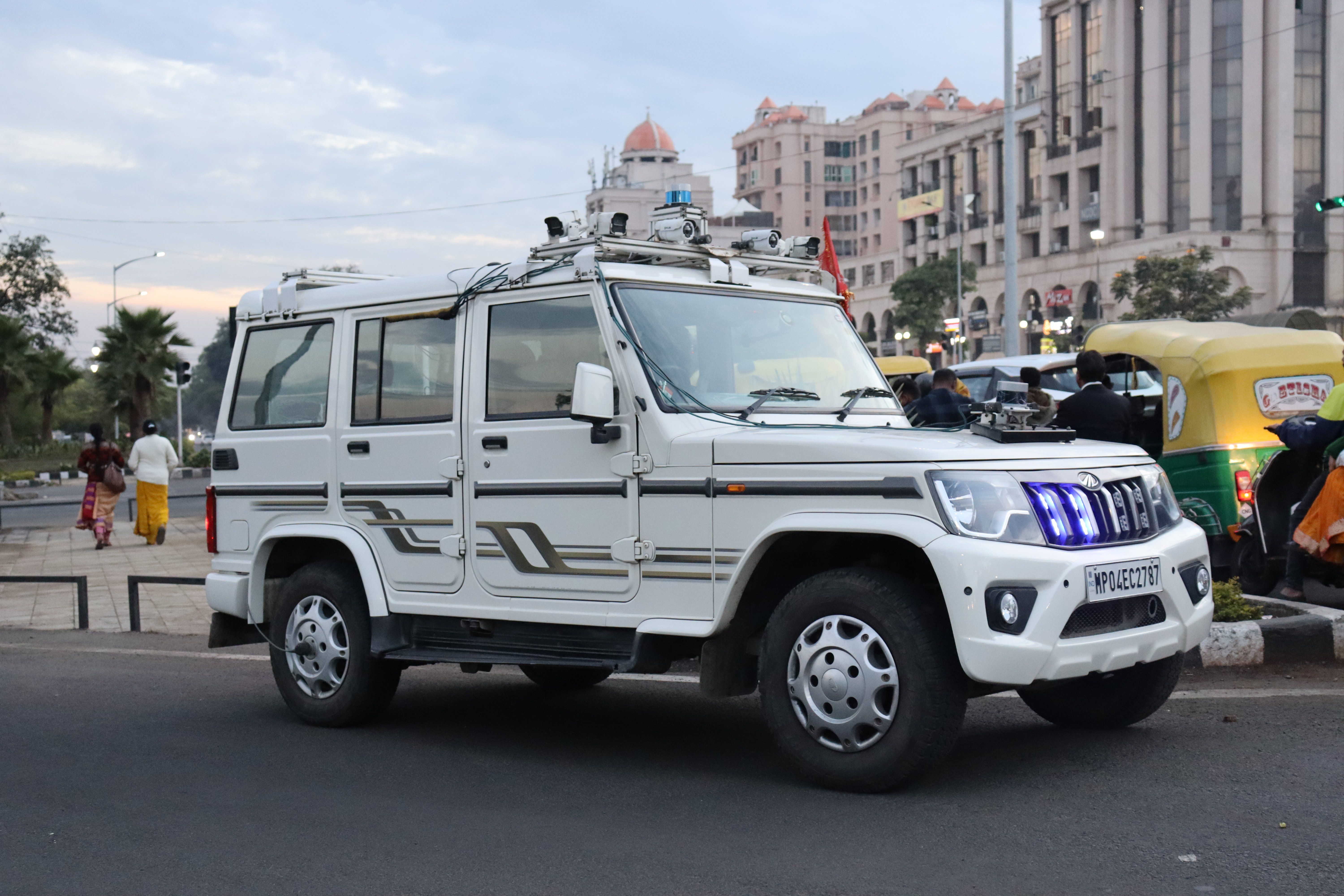 ​Swaayatt Robots SUV with a suite of sensors including lidar and gps on top on a road in India.