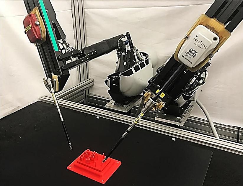 Robotic arms with surgical tools approach a red board with pegs.