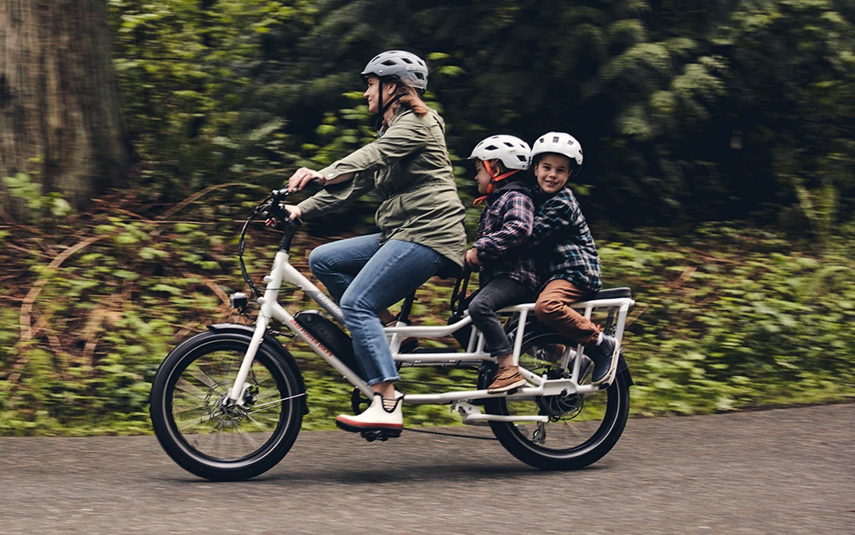 A woman and two children on a white electric bike