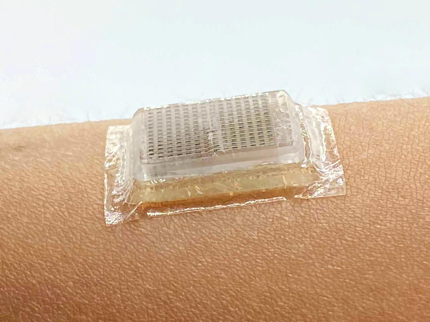 Close-up of a square rectangular clear device affixed to an arm.