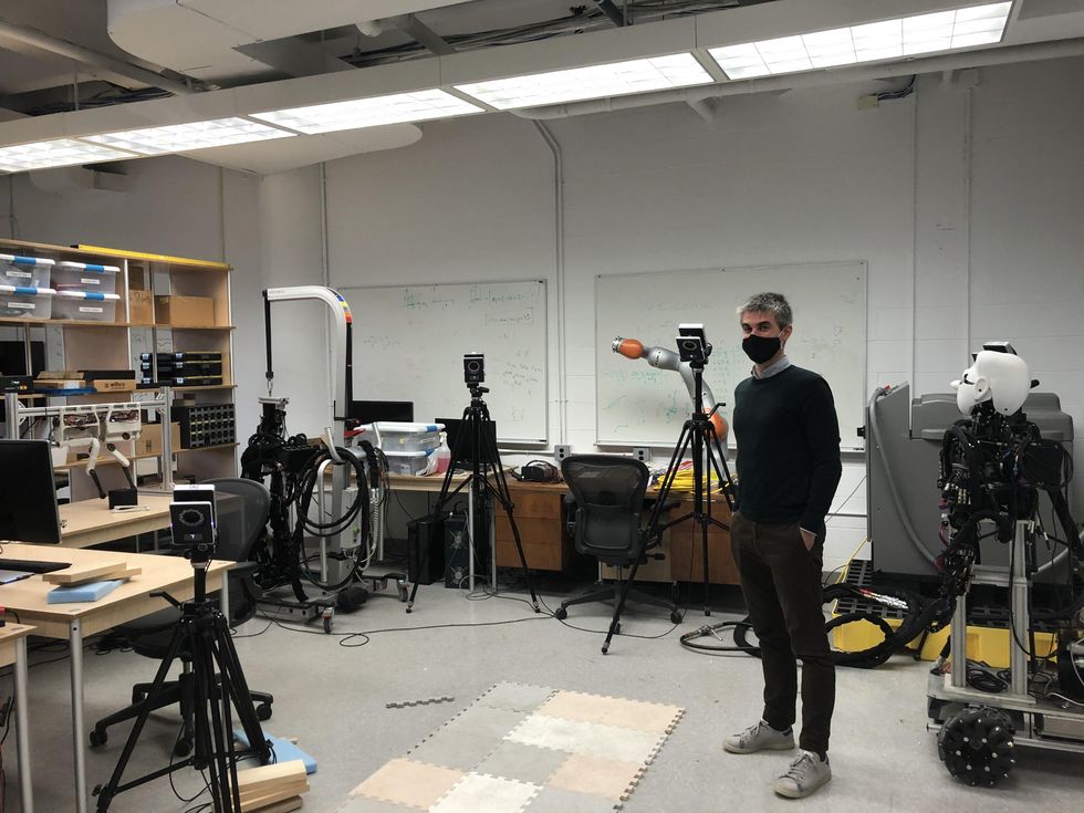 Ludovic Righetti stands among some of the key advances developed at his Machines in Motion Laboratory, including a next generation robotic arm and bipedal robot.u200b