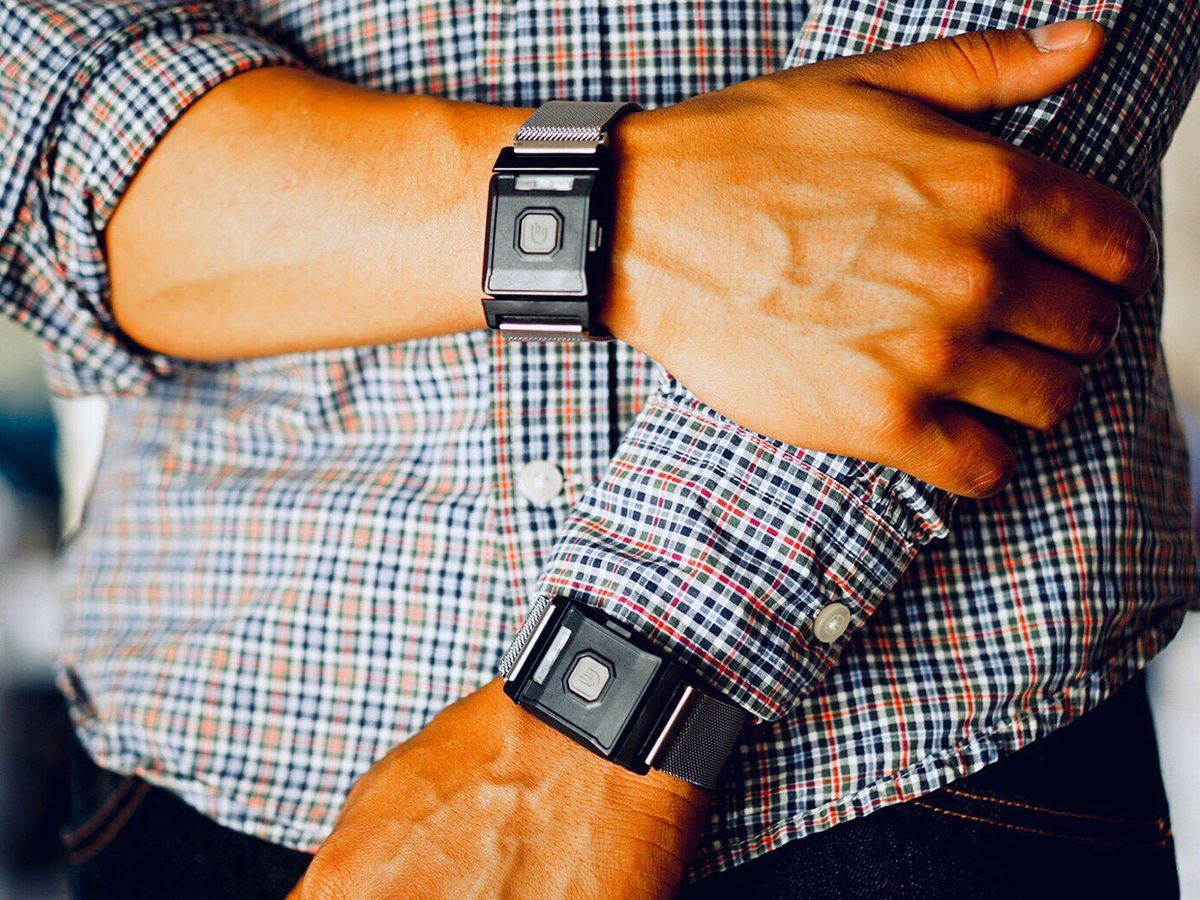 Man seen wearing the two TouchPoints devices, one on each wrist.