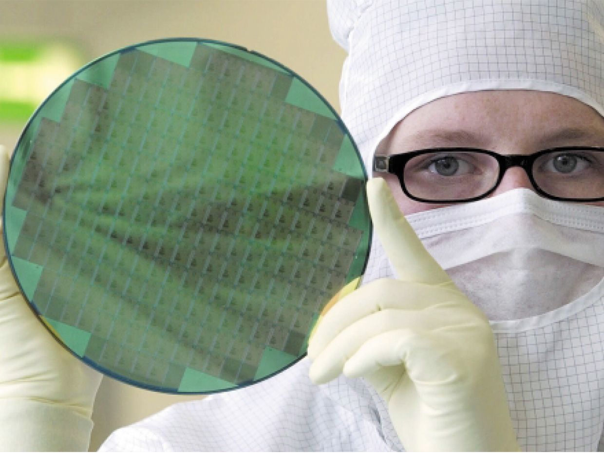 Man showing Athlon microprocessors fabricated on 200-mm wafers.