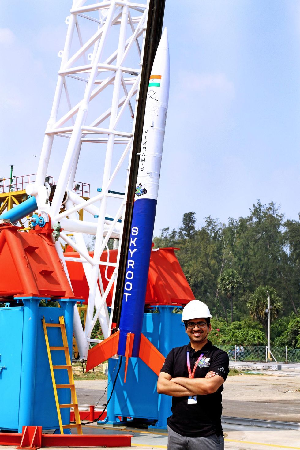 man standing in front of a rocket behind him