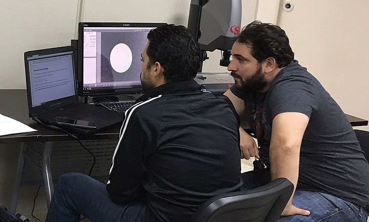 Marcos Santini [left], a student at the Puerto Rico Photonics Institute, works on optical dimensional metrology instruments with PRPI's lab technician, Francisco Rivera.