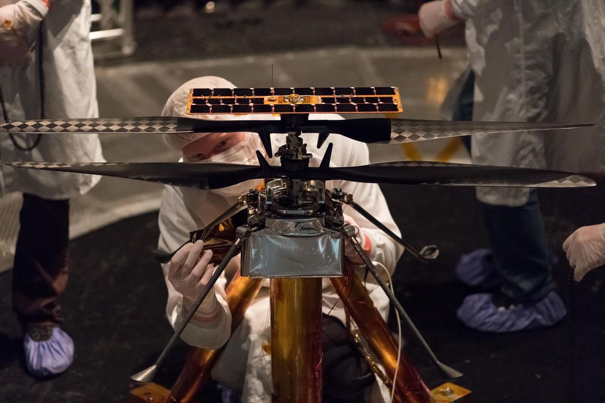 NASA engineers modifying the flight model of the Mars Helicopter inside the Space Simulator at NASA JPL.