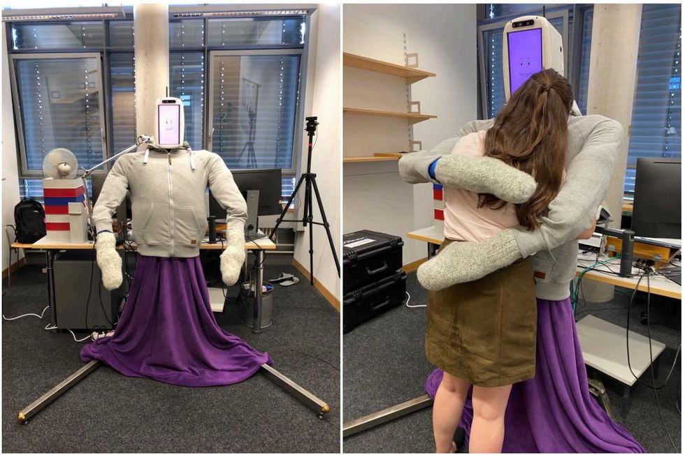 On left, a humanoid robot in a purple skirt and grey sweatshirt and grey mittens stands in an office. On right, the human robot hugging a woman.