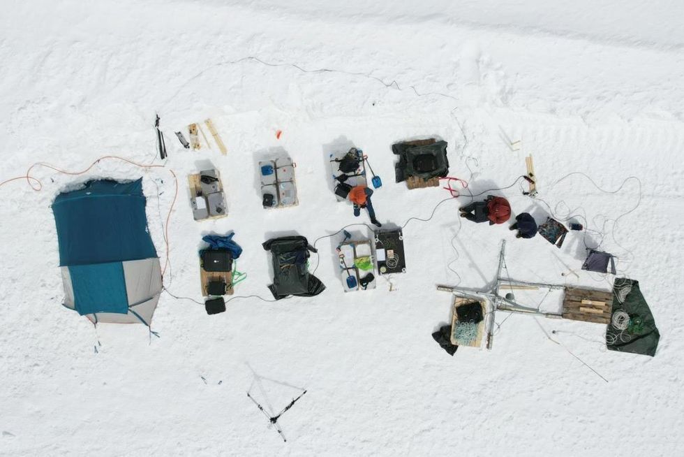overhead view of different colored boxes against a white background of snow