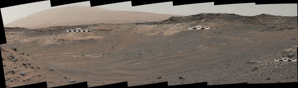 Panoramic image of the Mars surface showing a sandy depression with hills and mountains in the background