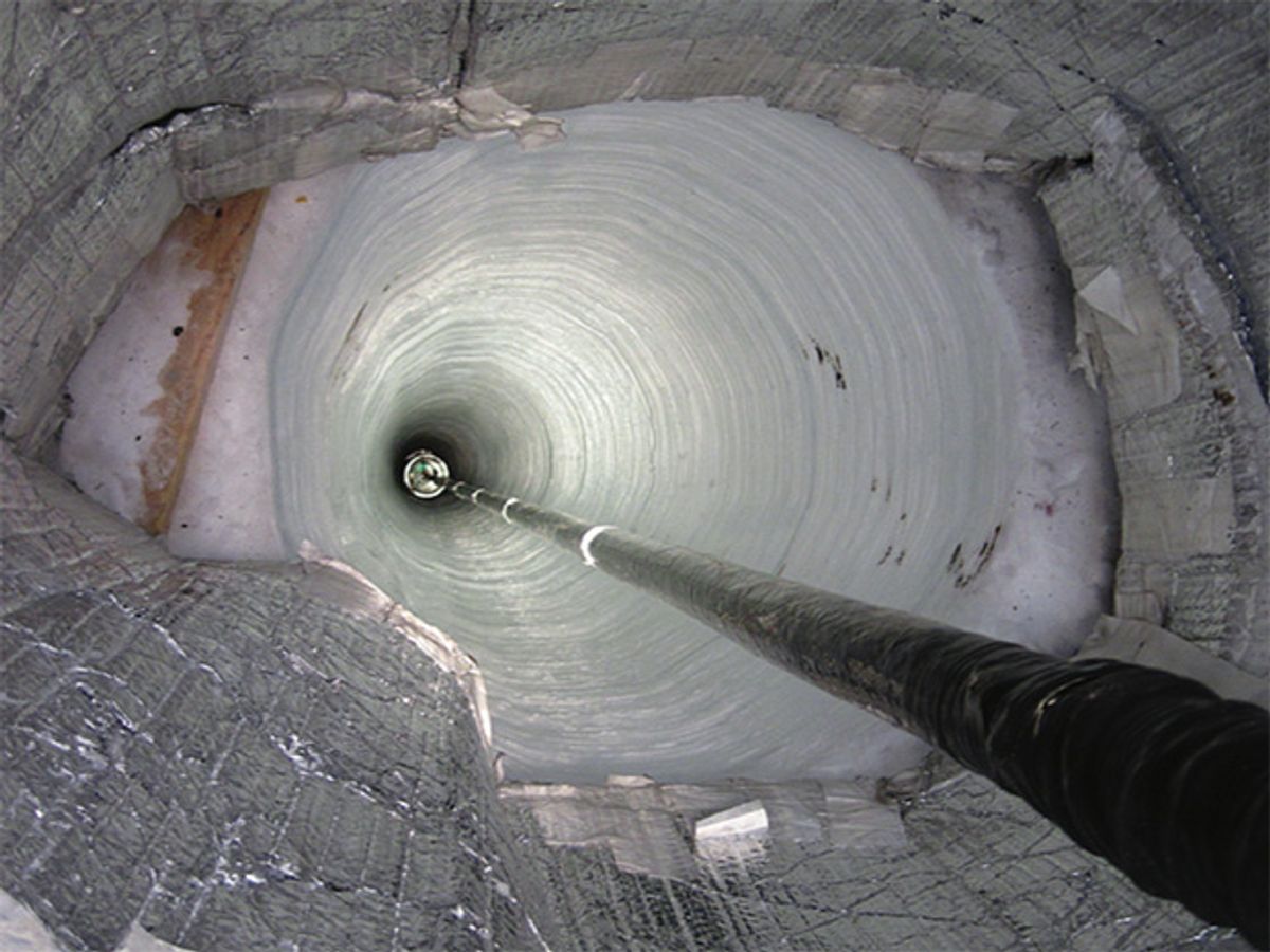 Particle detectors are lowered into a 2.5-kilometer-deep hole drilled into the Antarctic ice near South Pole Station.