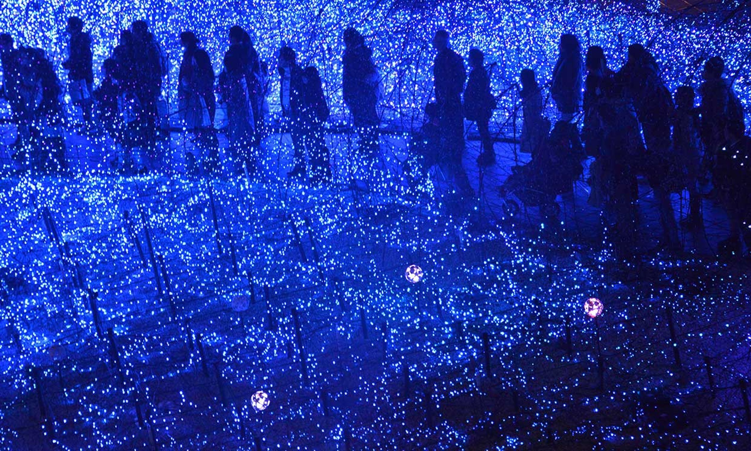 Pedestrians gather through the light installation 'Blue Ocean' at Tokyo's office district of Shiodome, 22 December 2014. 250,000 blue and white diodes (LED) are displayed until 12 January.