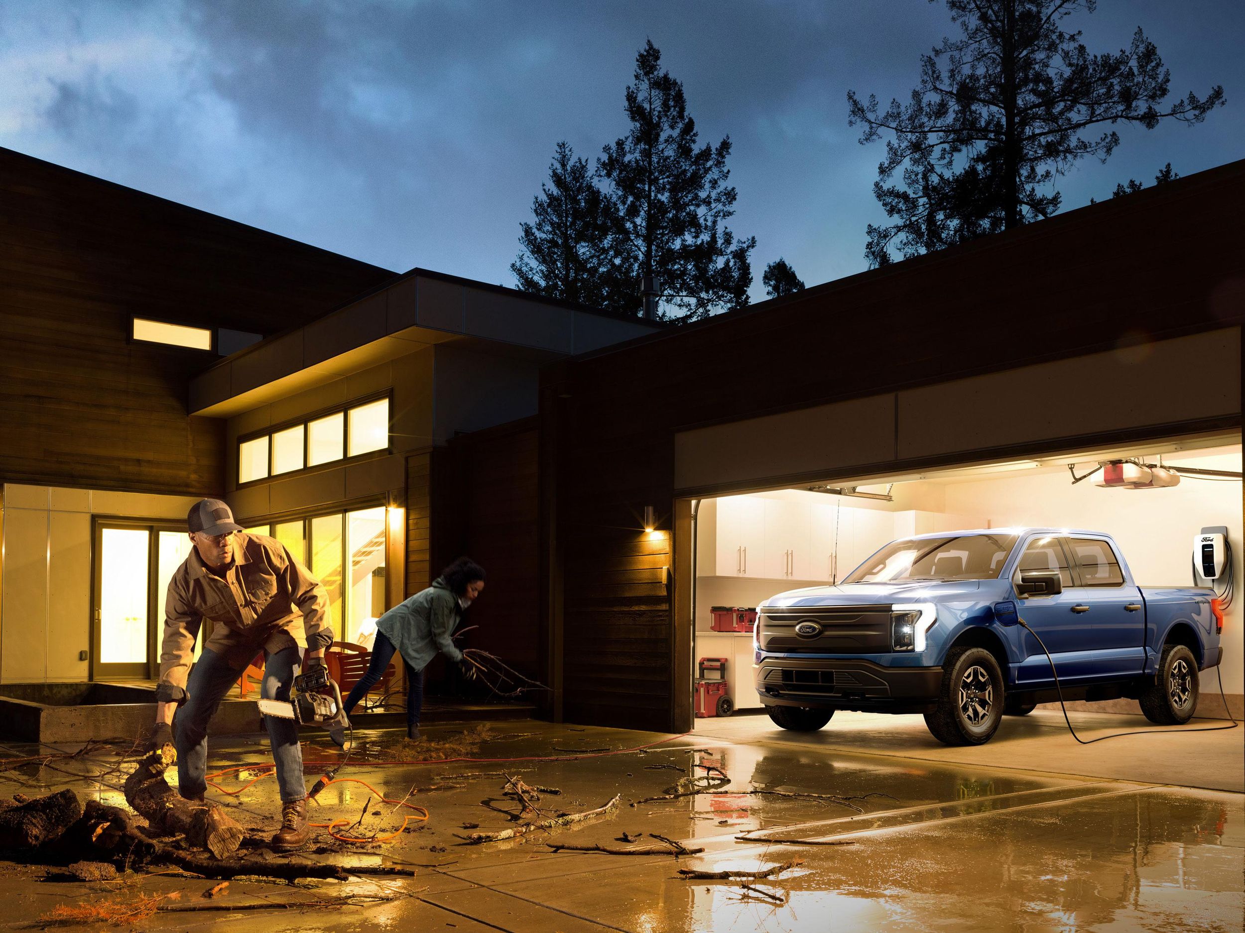 people clean up debris with the 2022 Ford F-150 Lightning Pro in a garage.