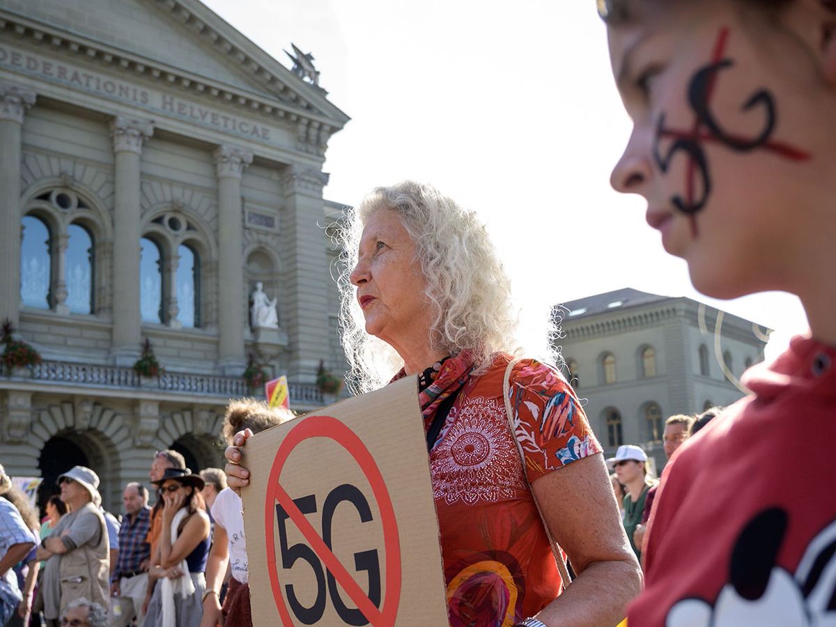 People take part in a nationwide protest against the 5G technology and 5G-compatible antenna deployment on 21 September in front of the Swiss House of Parliament in Bern.