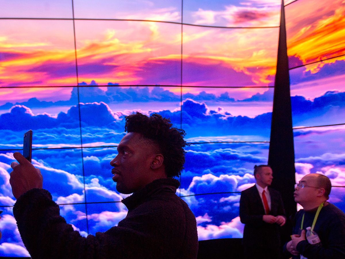 People walk through a display of LG OLED televisions at CES in Las Vegas, Nevada, January 9, 2018.