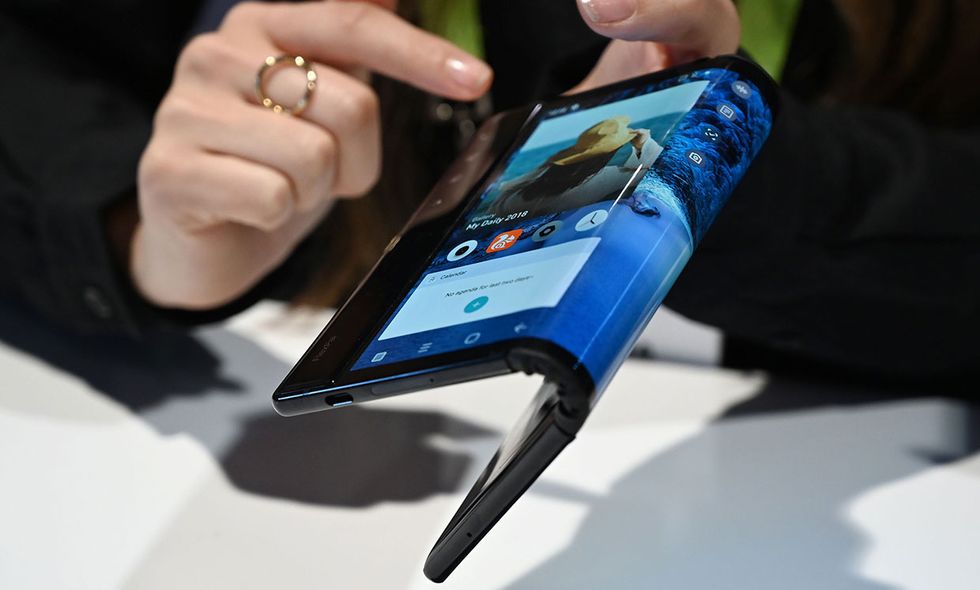 Person demonstrating the bendable display of the first commercial smartphone.