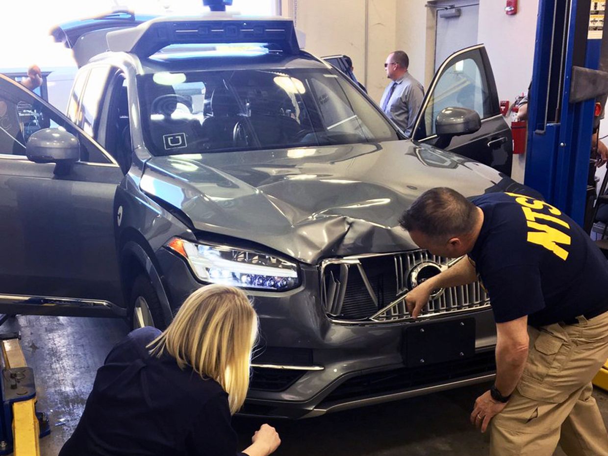 National Transportation Safety Board (NTSB) investigators examine a self-driving Uber vehicle involved in a fatal accident in Tempe, Arizona, U.S