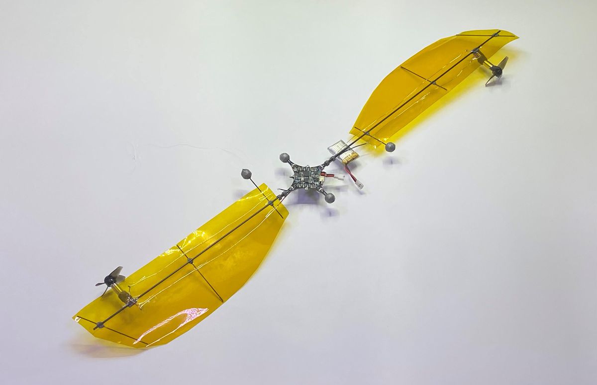 Photo of a drone made of two big wings connected at the middle, with small propellers on the leading edges of each wing