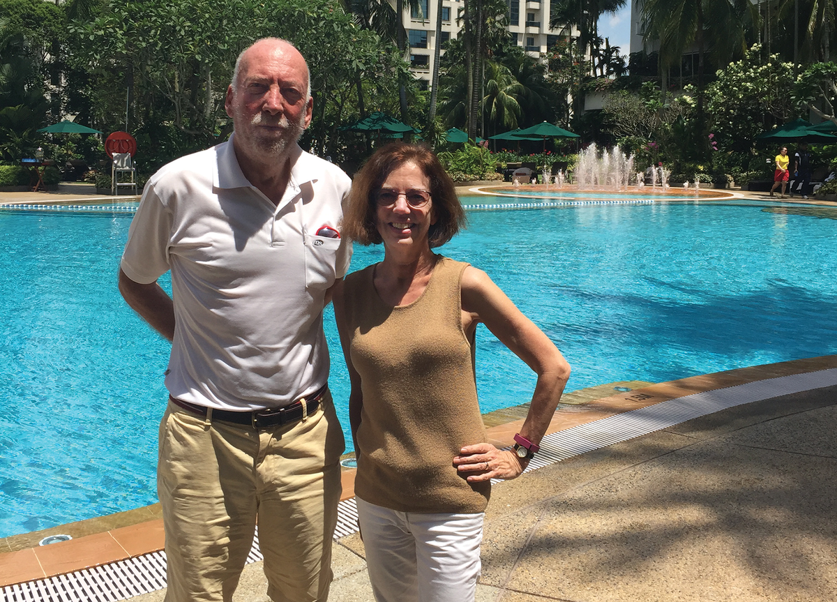 Photo of a man and a woman in front of a pool outside. 