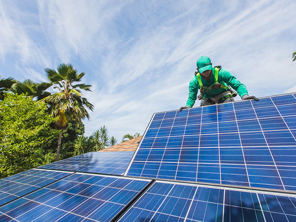 Photo of a SolarCity worker installing photovoltaic panels on a house in Hawaii.
