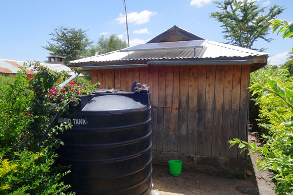 Photo of a water tank by a house.  