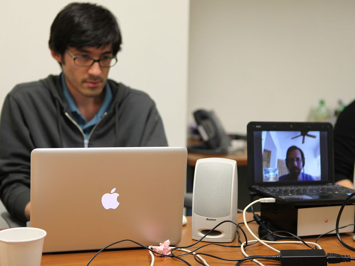 Photo of Erico Guizzo teleconferencing at table.