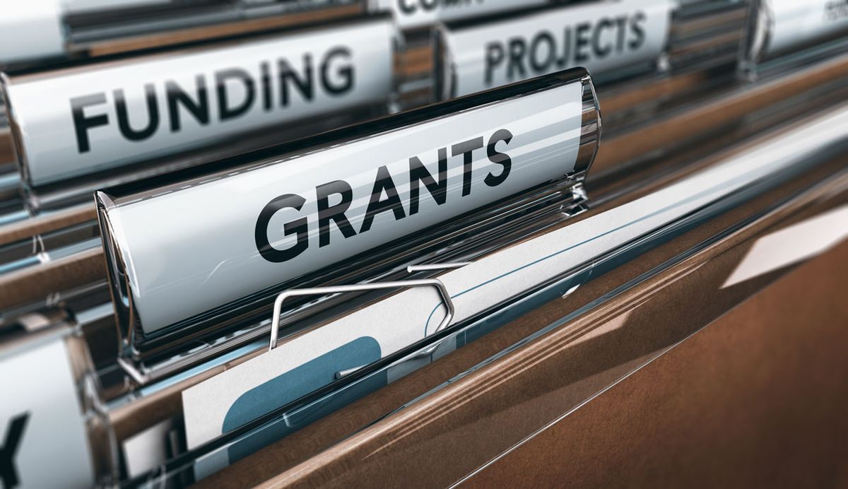 Photo of folders with one labeled "grants".