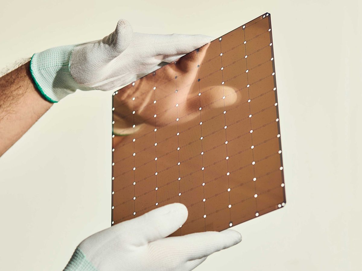 Photo of gloved hands holding wafer-scale chip.