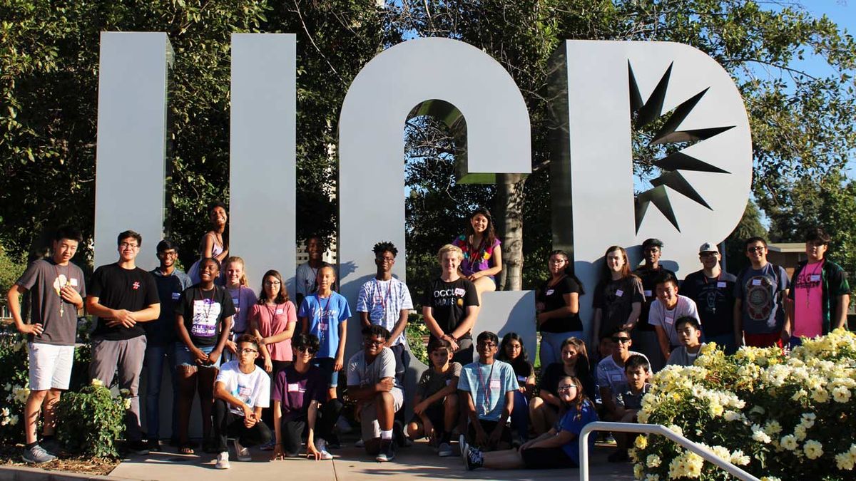 Photo of kids standing in front of a UCR sign