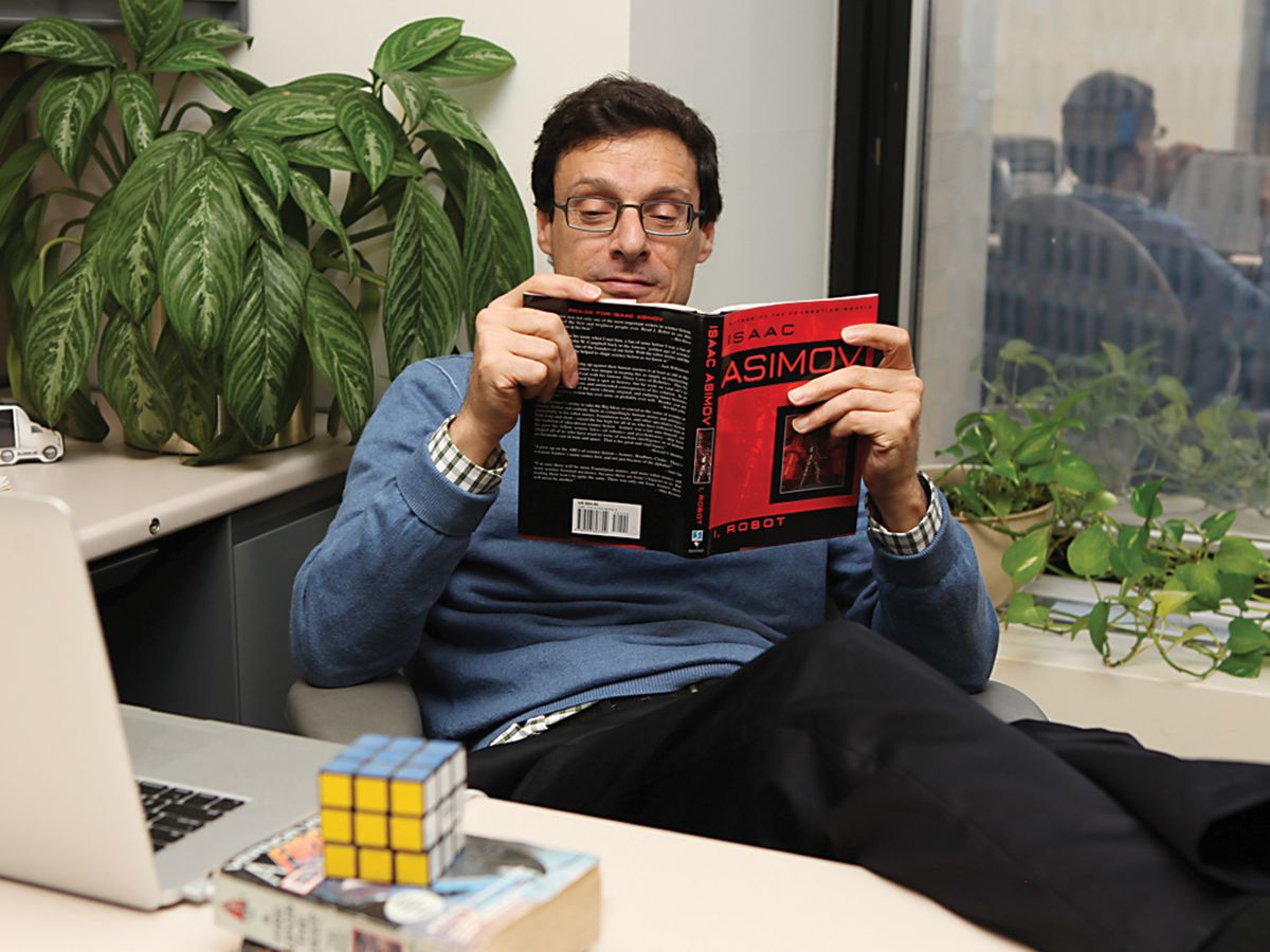 photo of man reading asimov at desk