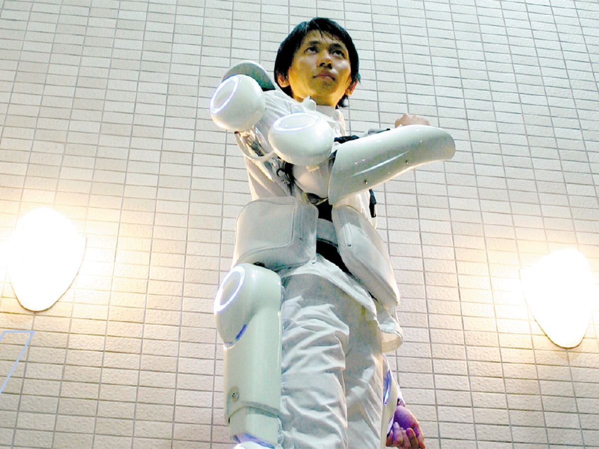 Photo of person wearing HAL-5, a powered robotic suit designed to help elderly and disabled people walk and carry things.