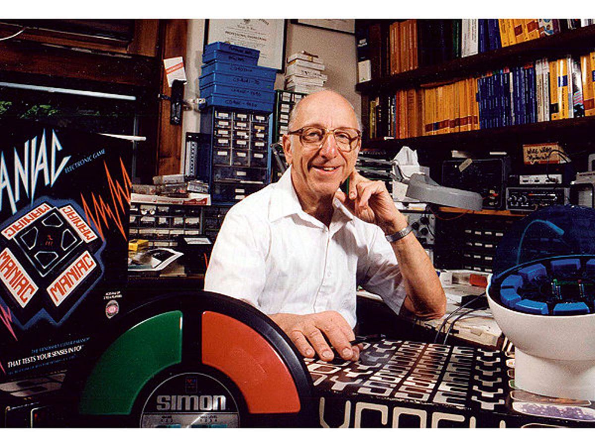 Photo of Ralph Baer, surrounded by a number of gaming toys.