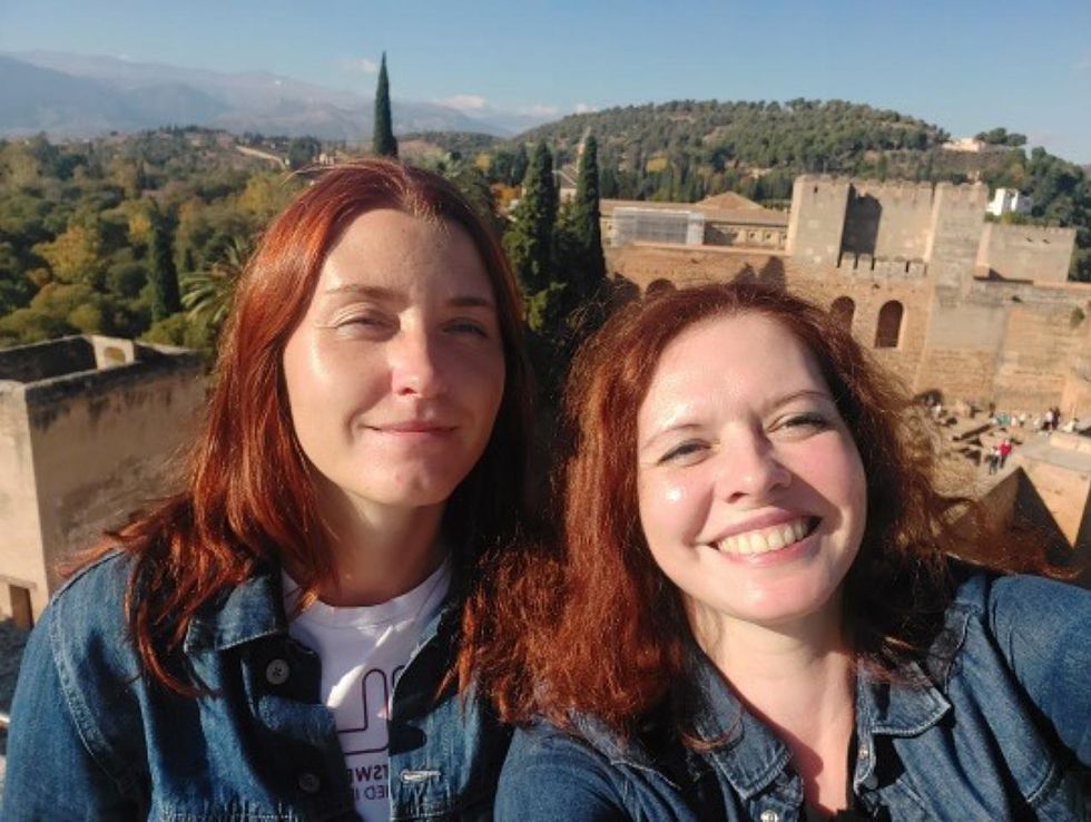 Photo of two smiling women with red hair with a castle in the background