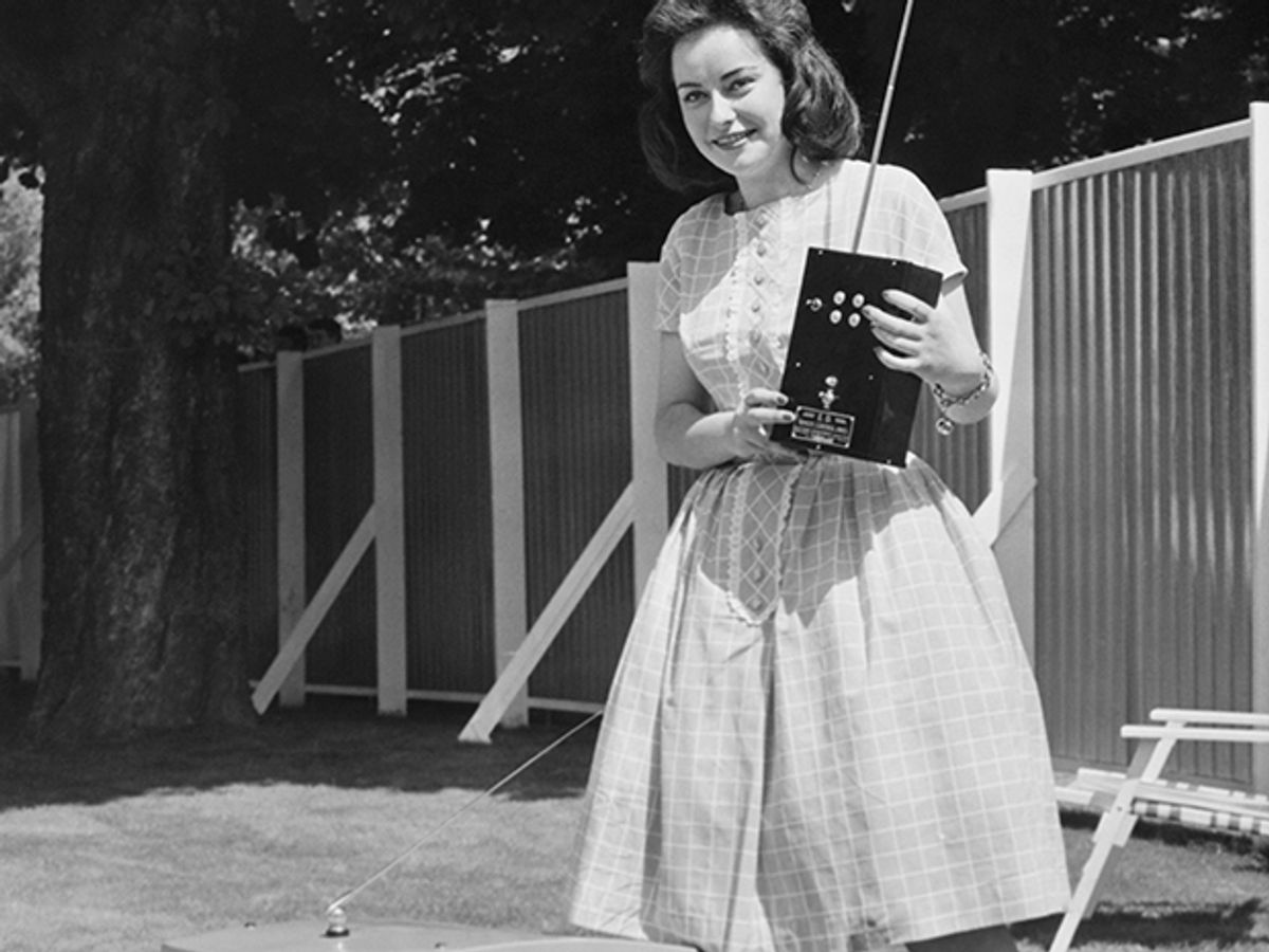 Photo of woman with the H.C. Webb & Co. radio-controlled electric lawn mower.