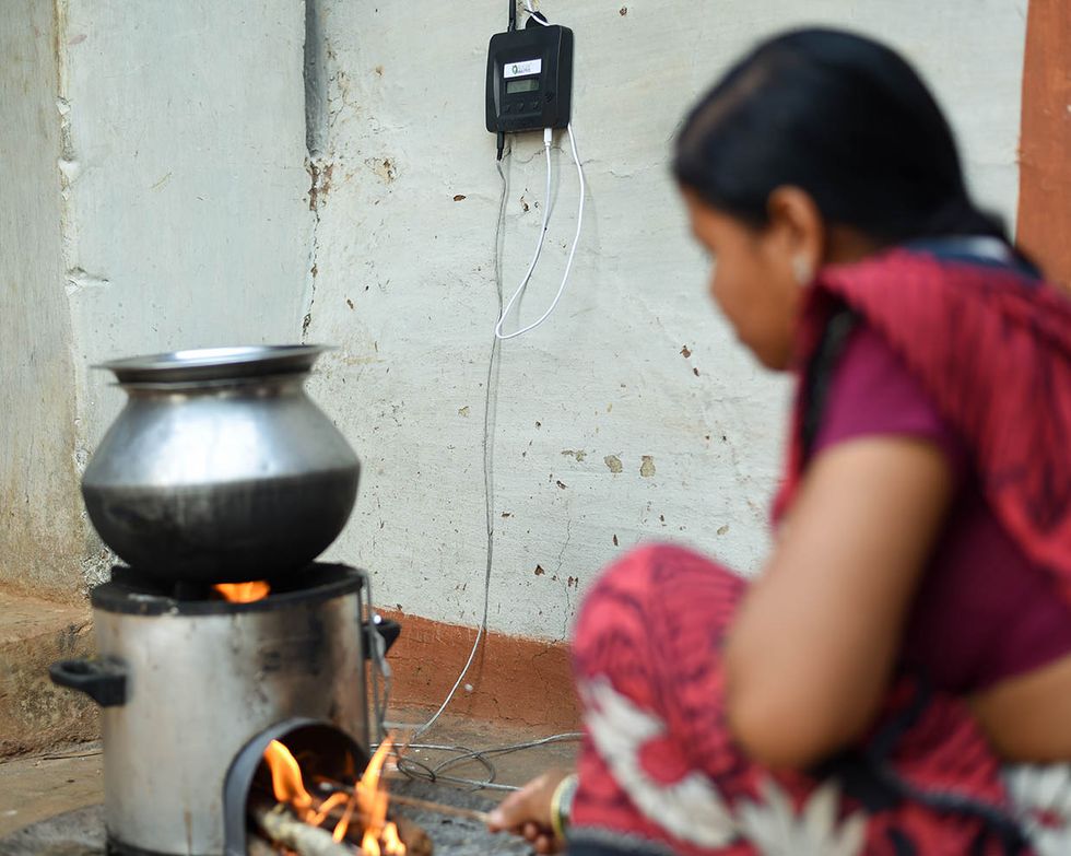 Photo showing woman with improved cookstove.