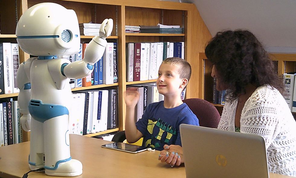photograph of a child with a QT robot
