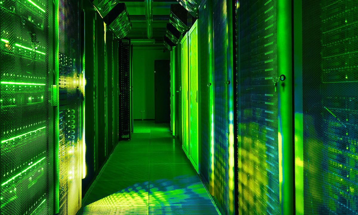 Photograph of a data center with green lights.