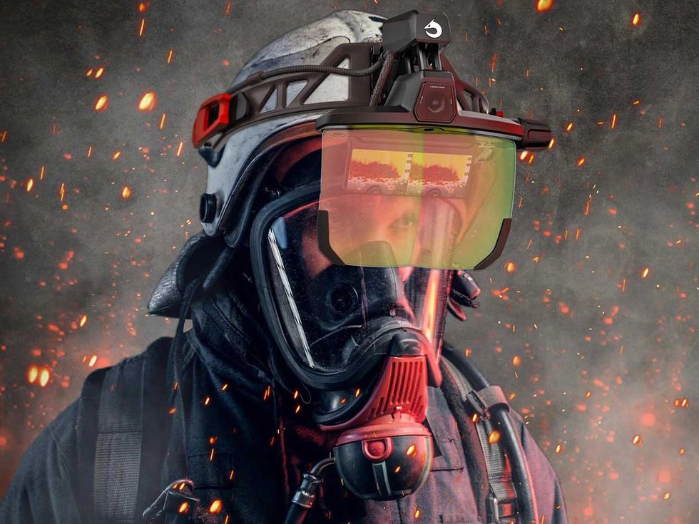 Photograph of a firefighter with the Longan Vision FVS augmented-reality visor showing thermal imaging