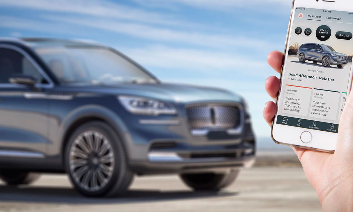 Photograph of a Lincoln Aviator in the background with a hand holding the Phone as Key app open on a smartphone.