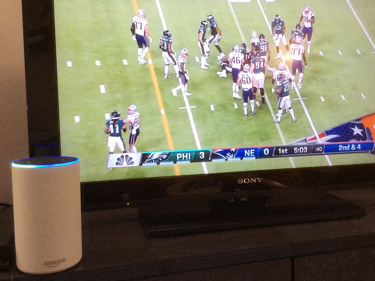 Photograph of Amazon's Alexa in front of a tv with the 2018 Super Bowl.