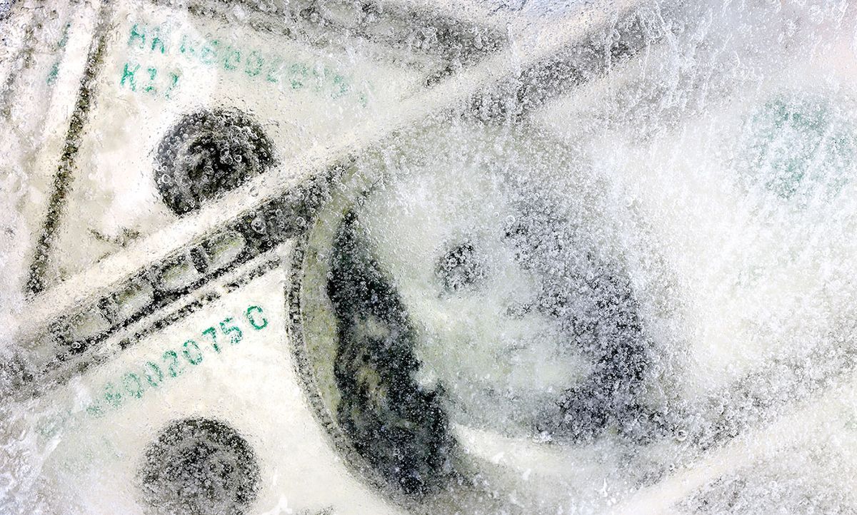 Photograph of money behind a layer of ice.