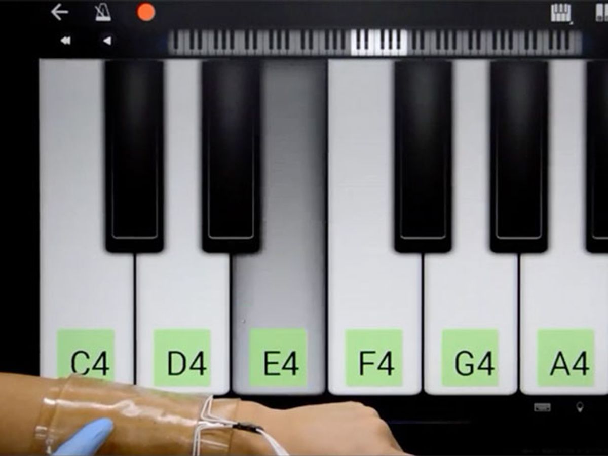 Playing a virtual piano using a stretchable touch pad on a person's forearm.