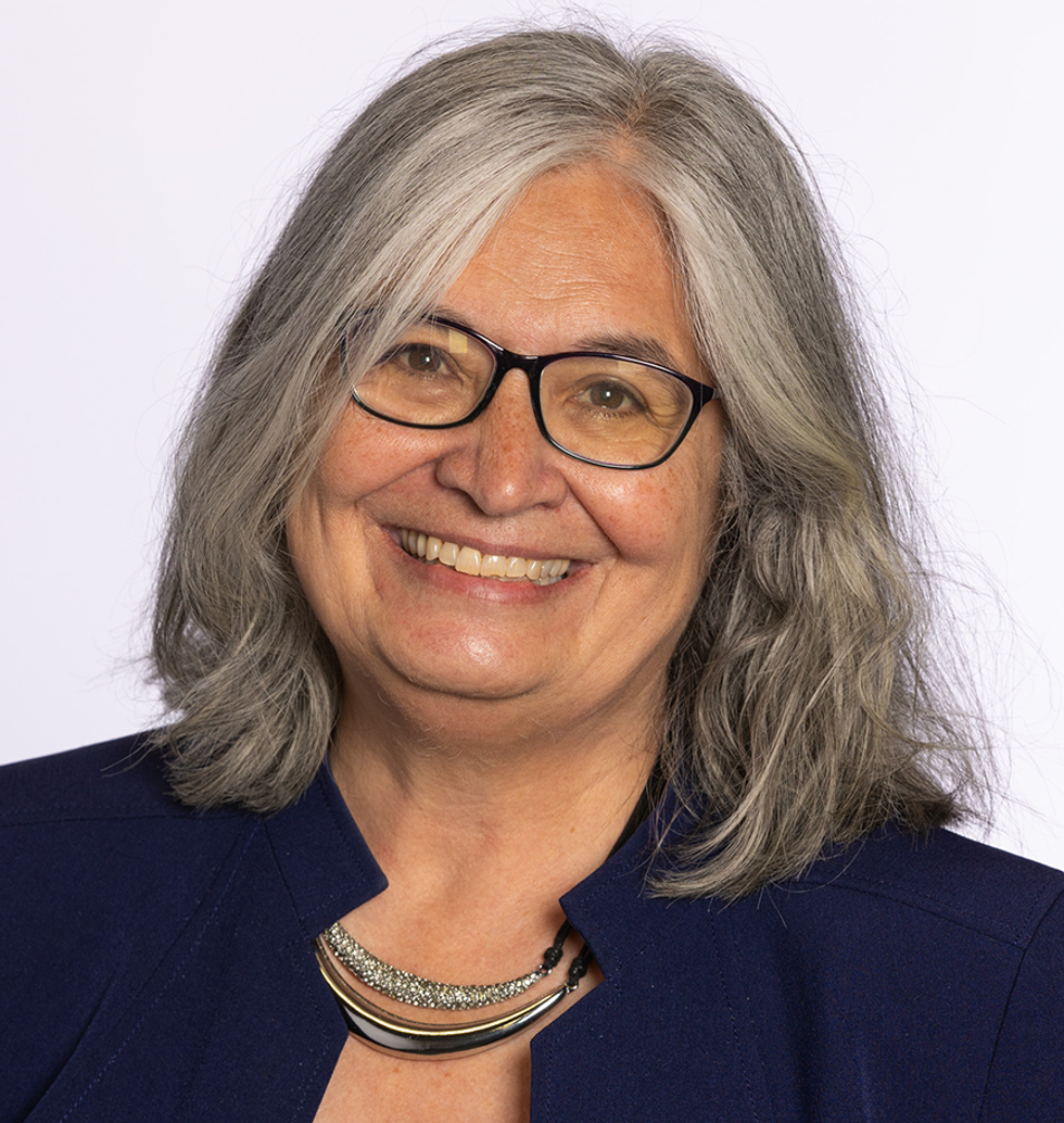 Portrait of a smiling woman with gray hair and glasses