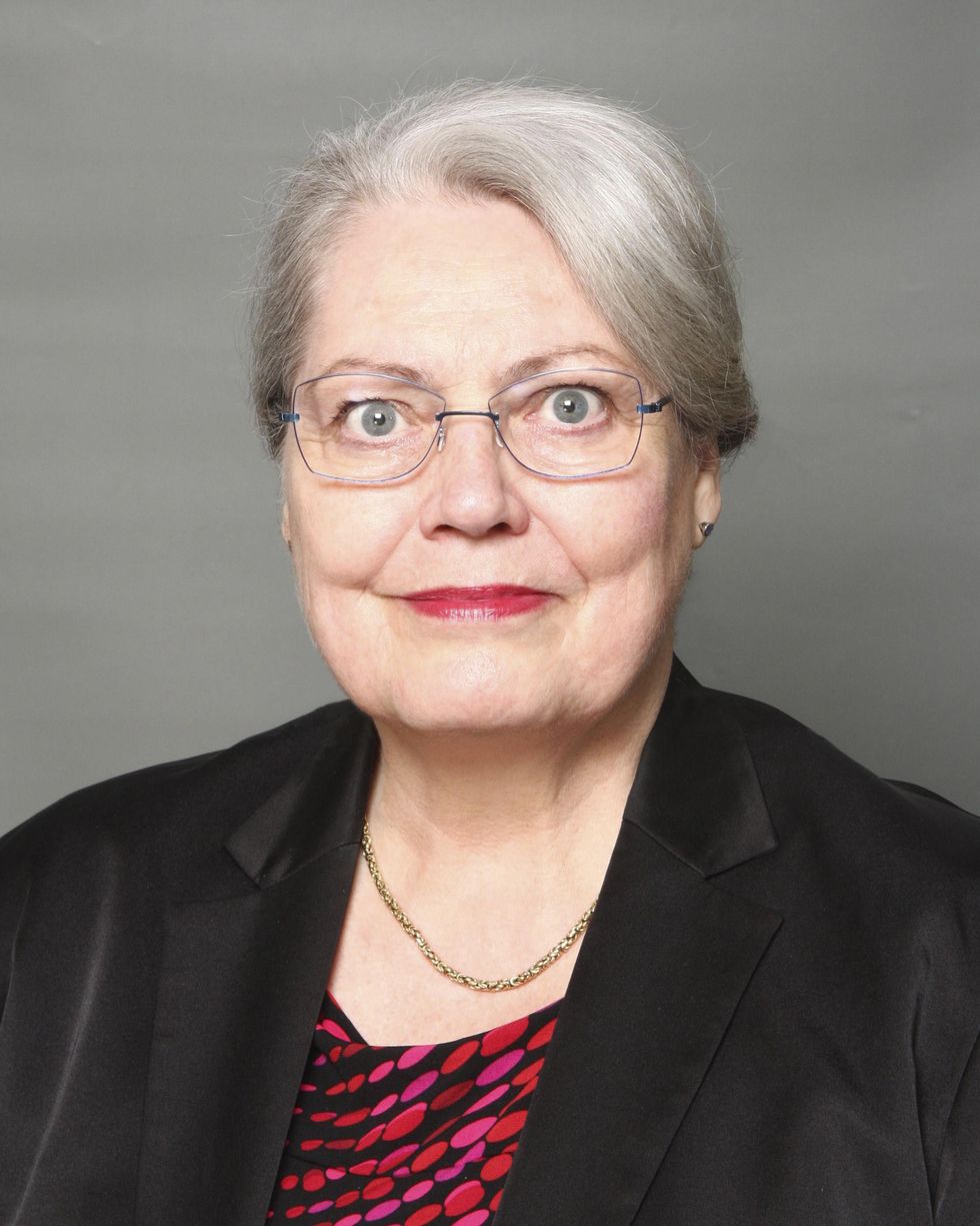 Portrait of a smiling woman with grey hair and glasses