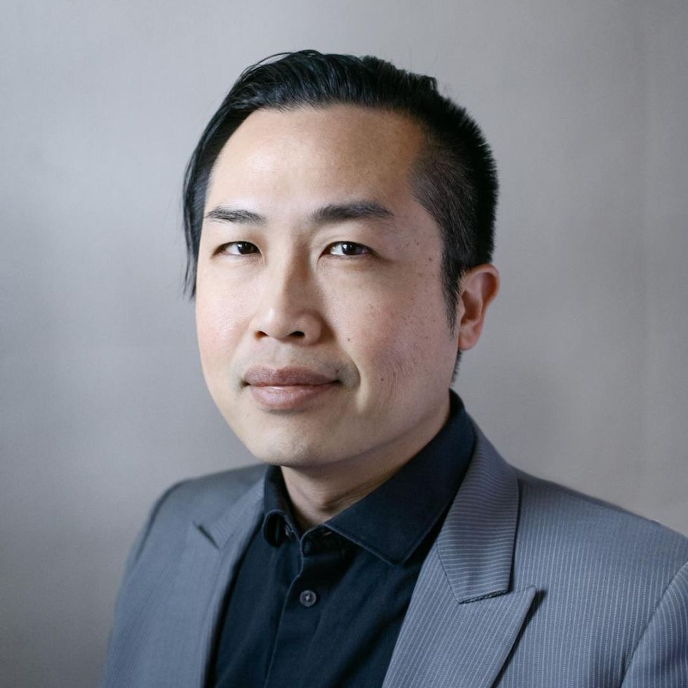 Portrait of David Truong stares at the camera against a gray background.