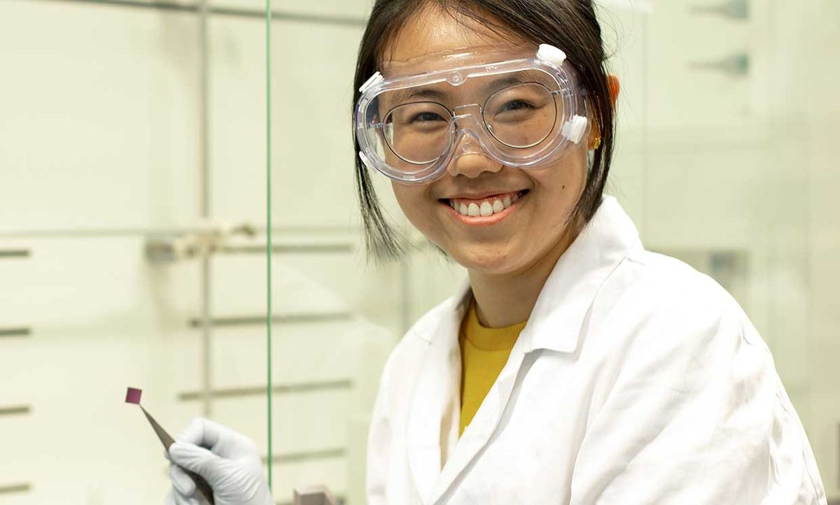 Researcher Yifang Wang is holding a silicon substrate on which a monolayer of MoS2 has been transferred.